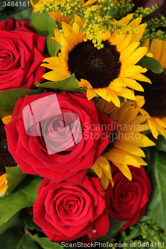 Image of Red roses and sunflowers in a floral arrangement