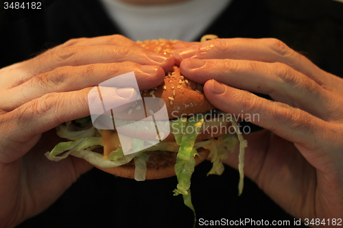 Image of Man holding a hamburger