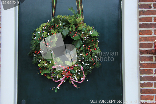 Image of Classic christmas wreath with decorations on a door