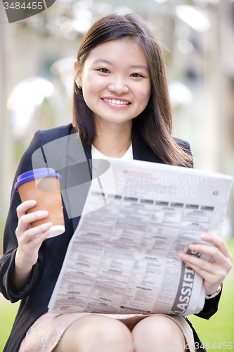 Image of Young Asian female business executive using laptop