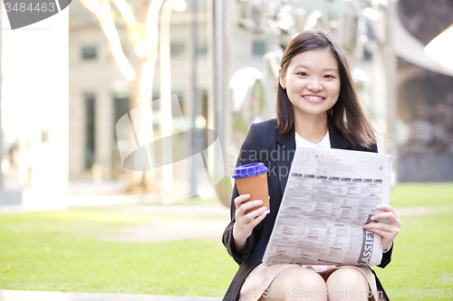 Image of Young Asian female business executive using laptop