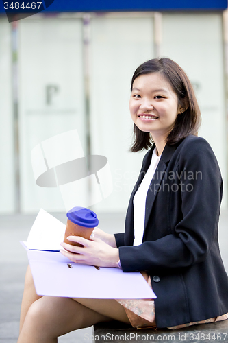 Image of Young female Asian business executive holding file