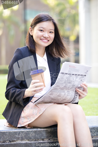 Image of Young Asian female business executive using laptop