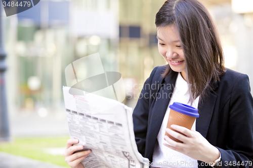 Image of Young Asian female business executive using laptop