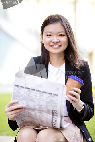 Image of Young Asian female business executive using laptop