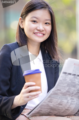 Image of Young Asian female business executive using laptop