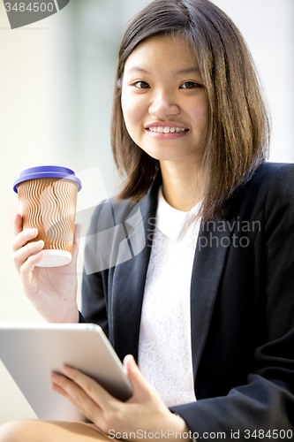 Image of Young Asian female business executive using tablet