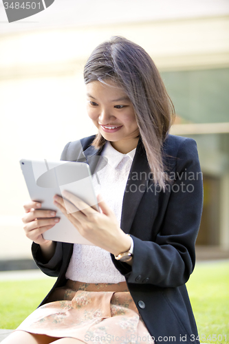 Image of Young Asian female business executive using tablet