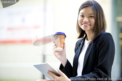 Image of Young Asian female business executive using tablet