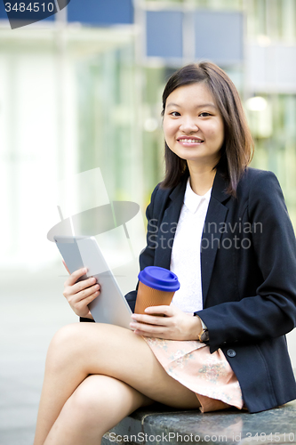 Image of Young Asian female business executive using tablet