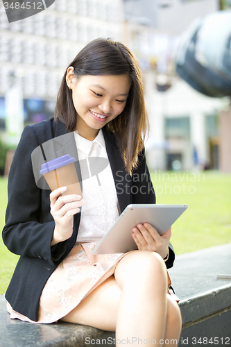 Image of Young Asian female business executive using tablet