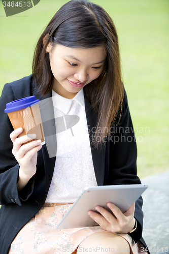 Image of Young Asian female business executive using tablet