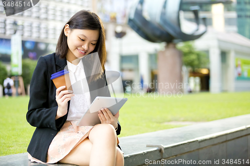 Image of Young Asian female business executive using tablet