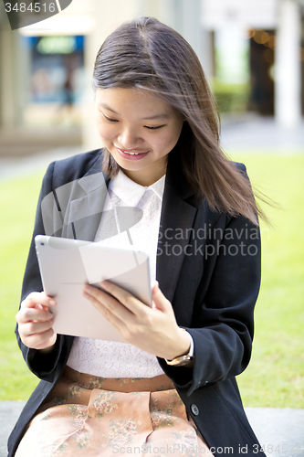 Image of Young Asian female business executive using tablet