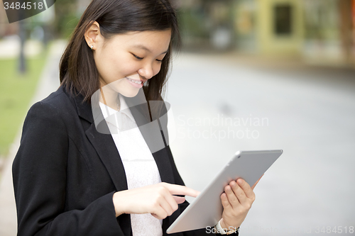 Image of Young Asian female business executive using tablet