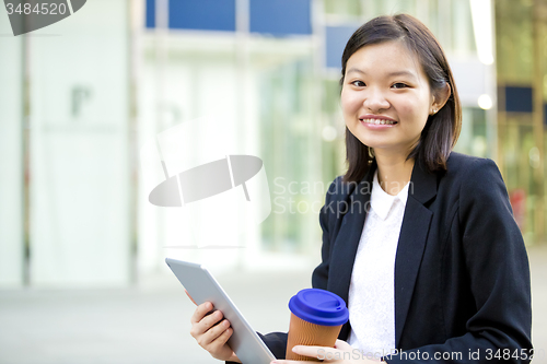 Image of Young Asian female business executive using tablet