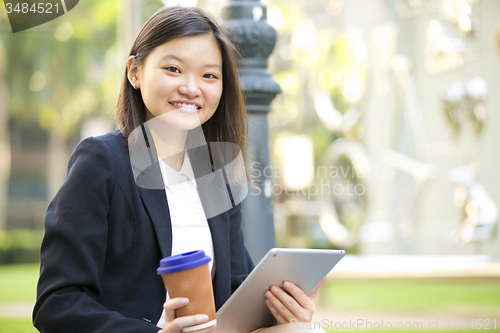 Image of Young Asian female business executive using tablet