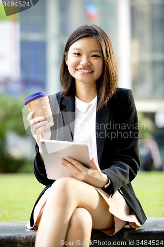 Image of Young Asian female business executive using tablet