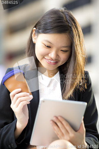 Image of Young Asian female business executive using tablet