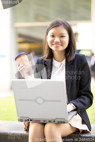 Image of Young Asian female business executive using laptop