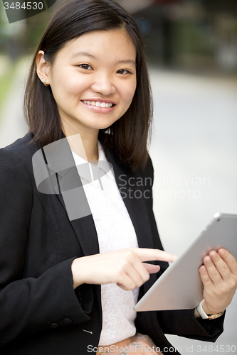 Image of Young Asian female business executive using tablet