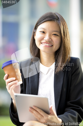 Image of Young Asian female business executive using tablet