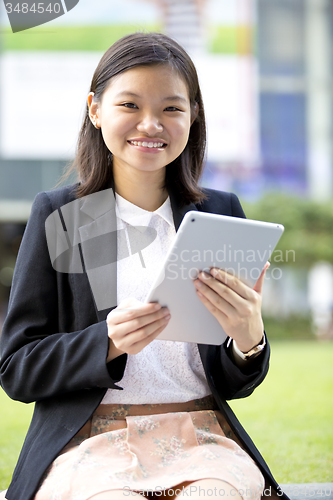 Image of Young Asian female business executive using tablet