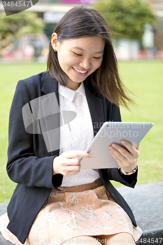 Image of Young Asian female business executive using tablet