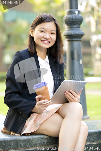 Image of Young Asian female business executive using tablet