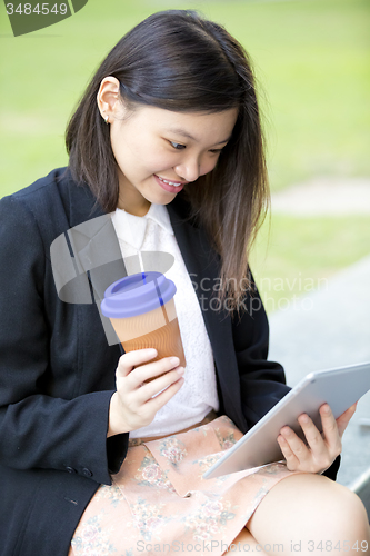 Image of Young Asian female business executive using tablet