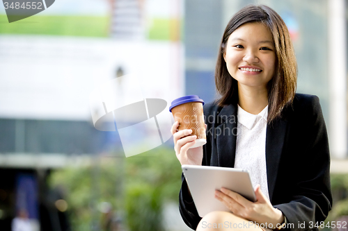 Image of Young Asian female business executive using tablet