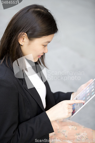 Image of Young Asian female business executive using tablet