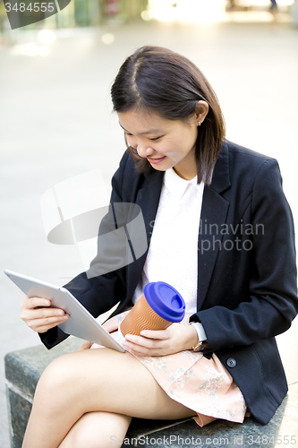 Image of Young Asian female business executive using tablet