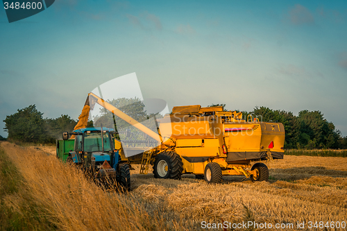 Image of Harvester loading grain on a truck