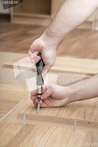 Image of Hands with a screwdriver