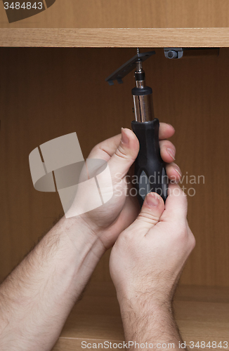 Image of Hands with a screwdriver