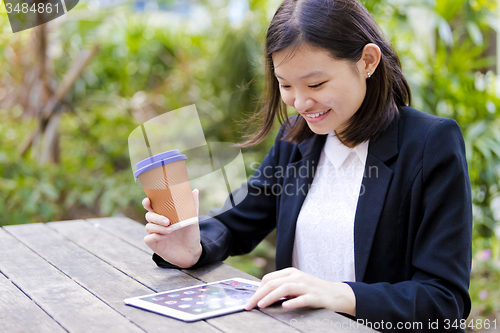 Image of Young Asian female business executive using tablet