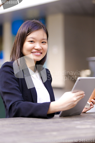 Image of Young Asian female business executive using tablet