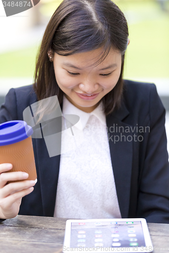 Image of Young Asian female business executive using tablet