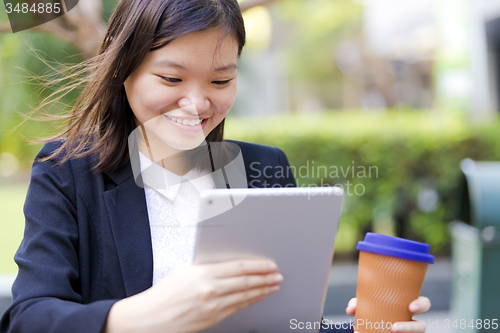 Image of Young Asian female business executive using tablet