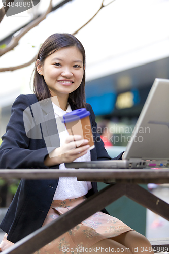 Image of Young Asian female business executive using laptop