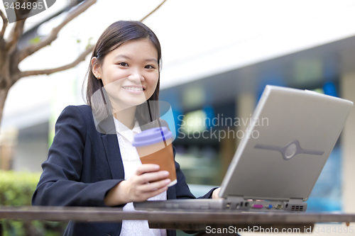 Image of Young Asian female business executive using laptop