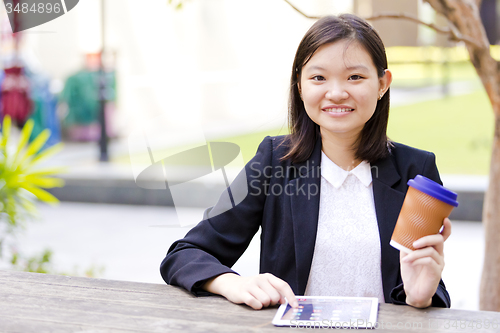 Image of Young Asian female business executive using tablet