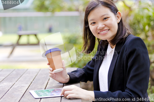 Image of Young Asian female business executive using tablet