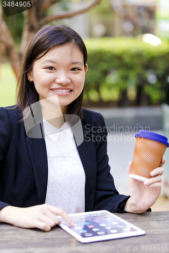 Image of Young Asian female business executive using tablet