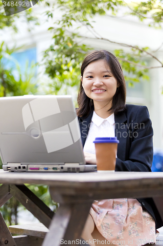 Image of Young Asian female business executive using laptop