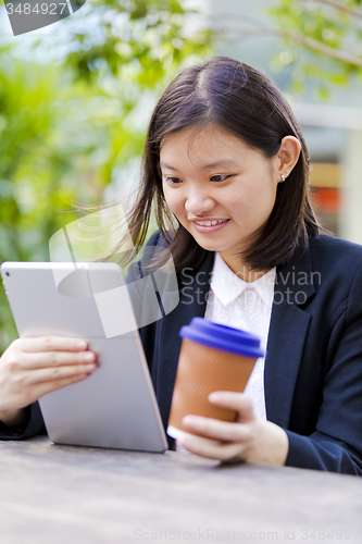 Image of Young Asian female business executive using tablet