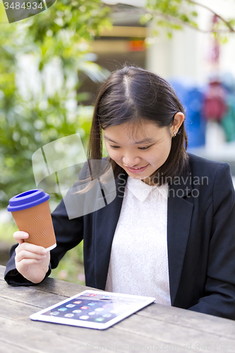 Image of Young Asian female business executive using tablet