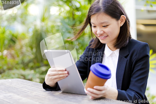 Image of Young Asian female business executive using tablet