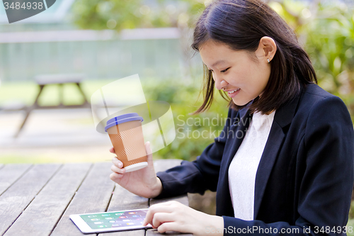 Image of Young Asian female business executive using tablet